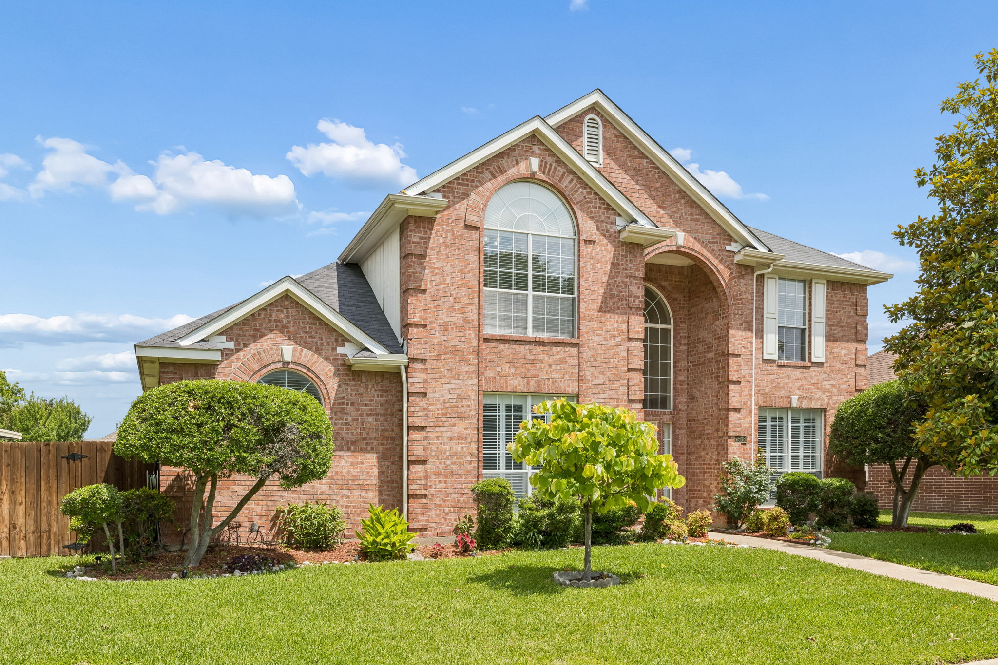 Exterior of 7513 Caribbean Drive in Rowlett TX with mature landscaping and magnolia tree