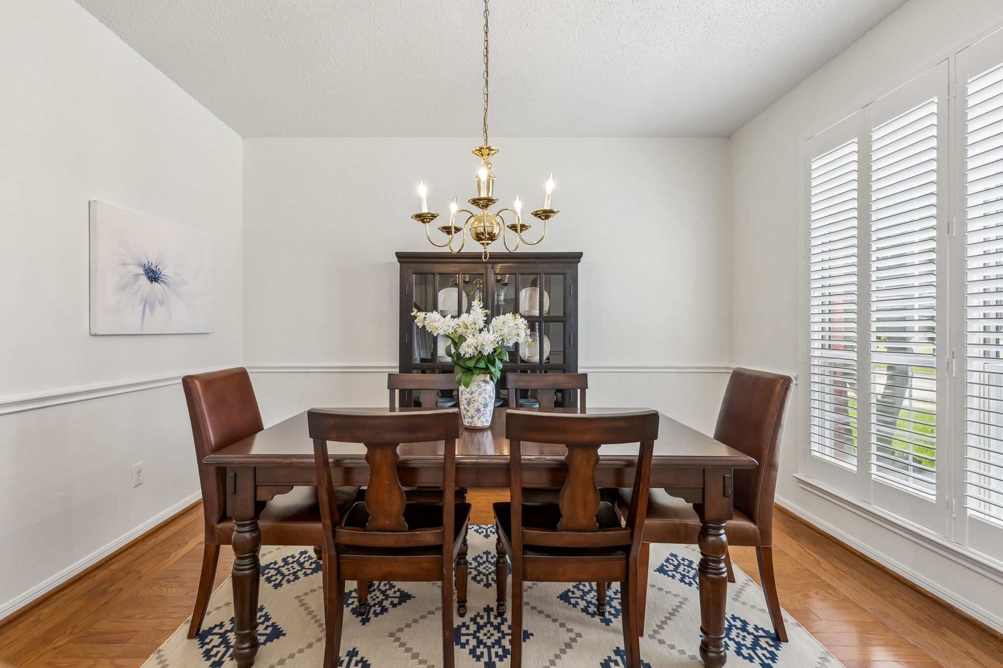 Formal dining room at 7513 Caribbean Drive in Rowlett TX with plantation shutters and wood flooring
