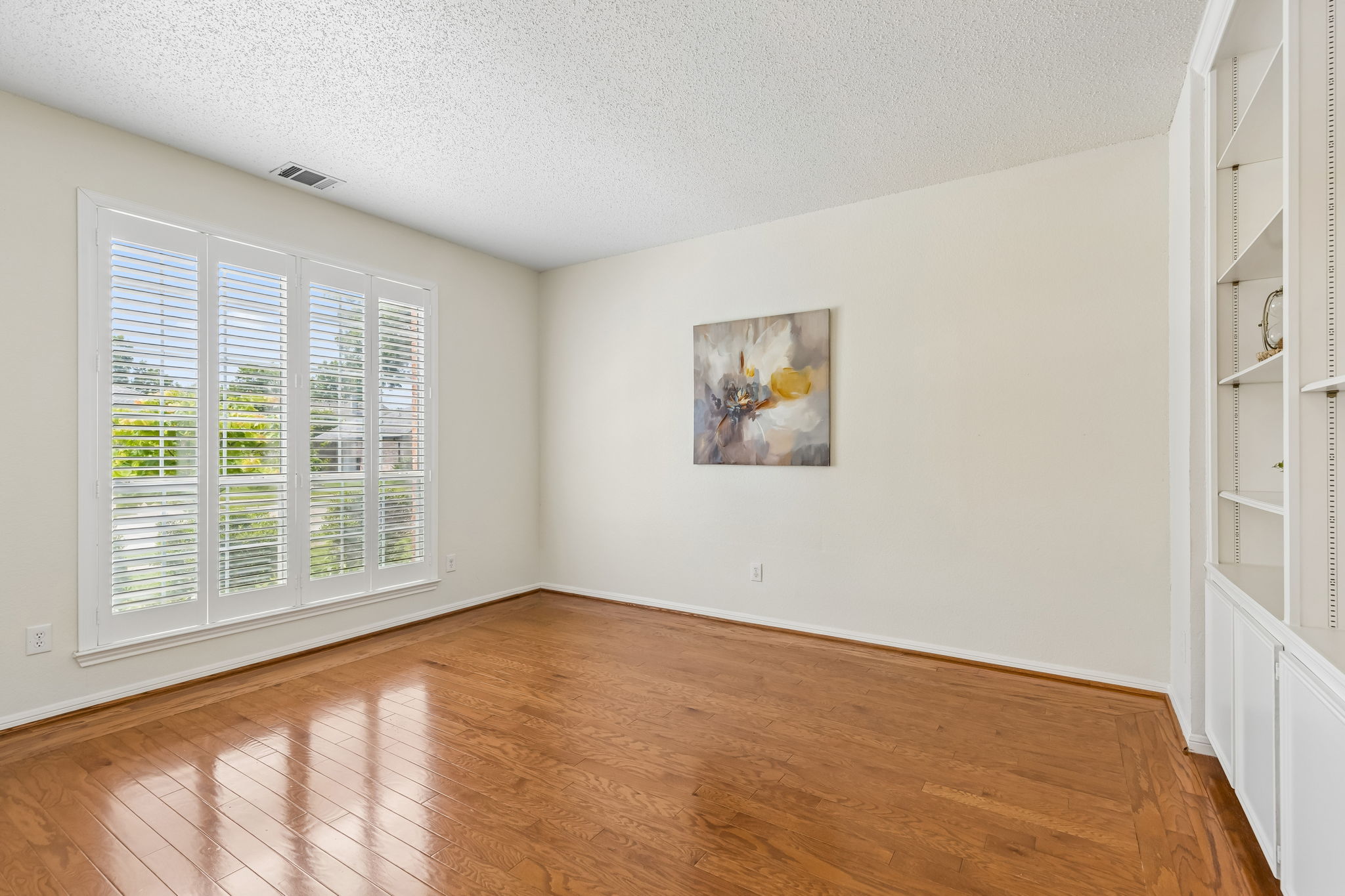 Den or home office at 7513 Caribbean Drive in Rowlett TX with built-in bookcases and plantation shutters
